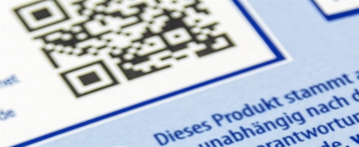 Close view of a printed QR code on a product label beside a linear barcode